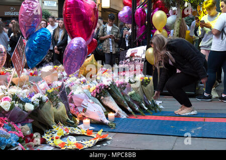 Manchester, Großbritannien. 22. Mai, 2018. Ein junges Mädchen Blätter Blumen am Denkmal in St. Ann's Square im Zentrum von Manchester, die 22 Opfer der Bombardierung der Manchester Arena zu erinnern, nach dem Konzert der amerikanischen Sängerin Ariana Grande gegeben. Bild: Rob Carter/Alamy leben Nachrichten Stockfoto