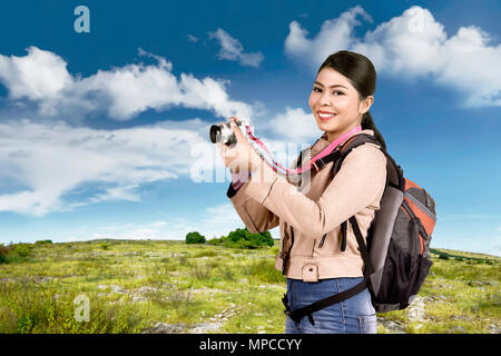 Schöne asiatische Touristen mit Kamera auf dem Feld Tasche Stockfoto