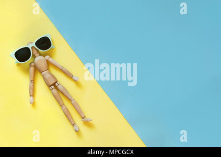Puppe mit frischen Zitronensäure Drink auf gelb wie Sand, blau wie Wasser. Konzept Reisen zum Strand. Blick von oben. Gefahr von Sonnenbrand. Uv-Schutz Stockfoto