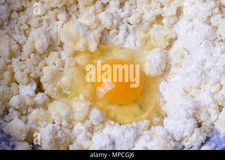 Teig mit Eiern und Löffel in eine Schüssel geben. Stockfoto