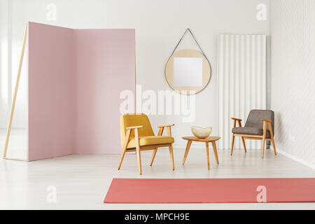 Gelb und Grau rosa Sessel in geräumigen Wohnzimmer mit Teppich und Modellerstellung Stockfoto
