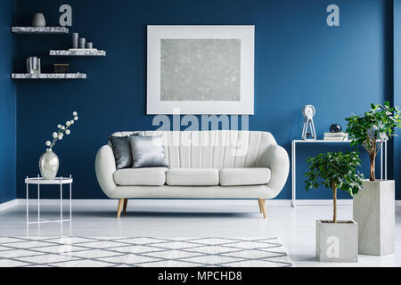 Weiß und Blau Wohnzimmer mit einem Sofa, Malerei und Pflanzen in eckigen Töpfe Stockfoto