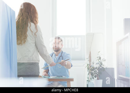 Gerne Arzt für Allgemeinmedizin geben Rezept für eine kranke Frau in einem Krankenhaus Stockfoto