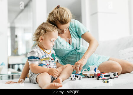 Ein kleiner Junge mit seiner Mutter in ein Spielzimmer. Das Porträt einer schwangeren Frau und ihres Toddler boy Zeit miteinander zu verbringen. Stockfoto