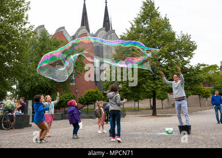 Europa, Deutschland, Köln, Mann macht riesige Seifenblasen am Rhein Garten im alten Teil der Stadt. Europa, Deutschland, Koeln, Mann macht grosse Stockfoto