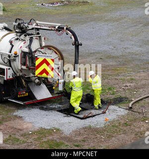 Handwerker in der High vis Jacken Betriebsmittel zu löschen Abflüsse Stockfoto