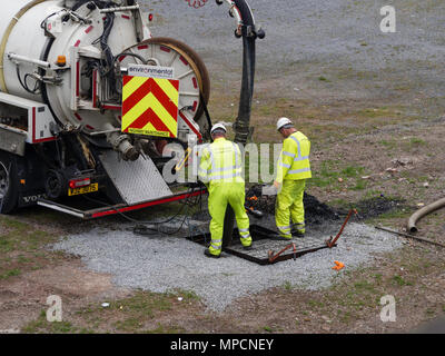 Handwerker in der High vis Jacken Betriebsmittel zu löschen Abflüsse Stockfoto