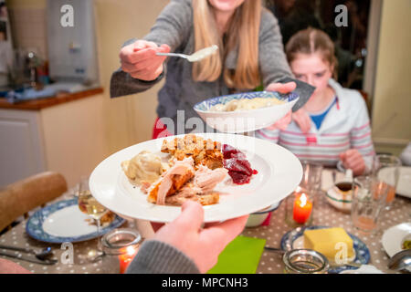 Frau serviert Speisen zu Ihrer Familie für Thanksgiving. Stockfoto