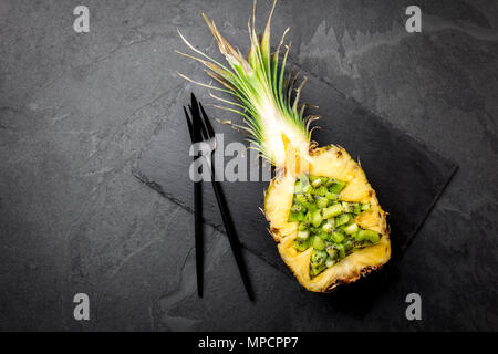 Urlaub Diät Konzept oder tropische Weihnachten Menü Konzept. Weihnachtsbaum aus Ananas und Kiwi auf Schiefer. Ideen für Weihnachten Neujahr Menü Stockfoto