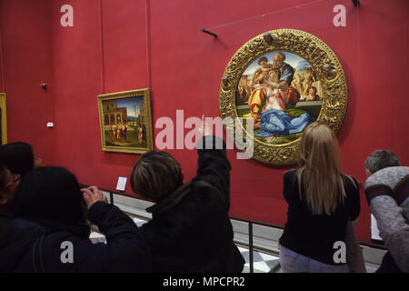 Besucher vor dem Gemälde "Oni Tondo" durch die italienische Renaissance Künstler Michelangelo Buonarroti von ca. 1507 in den Uffizien (Galleria degli Uffizi) in Florenz, Toskana, Italien angezeigt datiert. Stockfoto