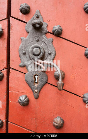 Alten rostigen sperren und Türgriff in Kronborg Slot: Eine alte rostige blockieren und auf eine hölzerne orange rot Türgriff verstärkt mit großen eisernen Nieten. Stockfoto