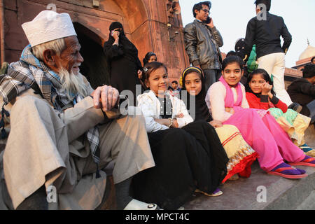 Indien, Neu-Delhi, muslimischen Mädchen sitzen auf der Treppe vor dem Eingang der Jama Masjid in der Altstadt von Delhi. Stockfoto