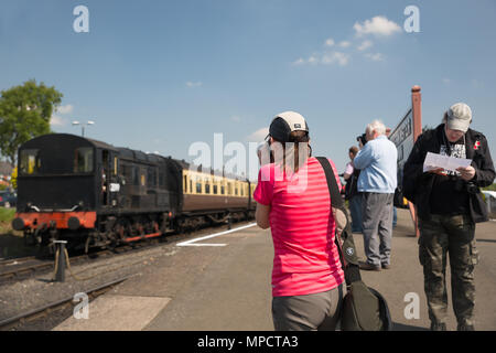 Ansicht der Rückseite des weiblichen Zug Enthusiast, tragen Baseball Cap & rosa T-Shirt, stehend auf der Plattform die Fotos des Dieselmotors bei SVR-Gala in der Sonne. Stockfoto