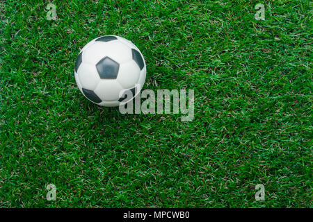 Tabelle Ansicht von oben Luftbild Fußball oder Football Saison Hintergrund. flaches Objekt Ball auf der künstlichen grünen Gras wallpaper legen. Freiraum für kreative Stockfoto