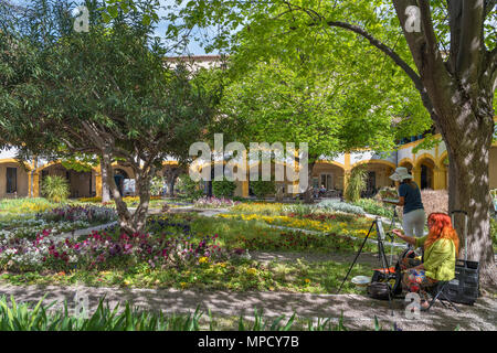 Künstler Malerei in den Innenhof des Krankenhauses in Arles, jetzt l'Espace Van Gogh nannte, Arles, Provence, Frankreich Stockfoto