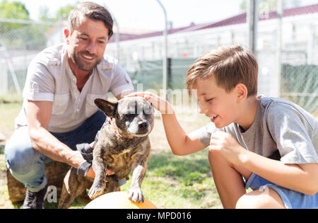 Vater und Sohn kümmert sich um verlassene Hund im Tierheim Stockfoto