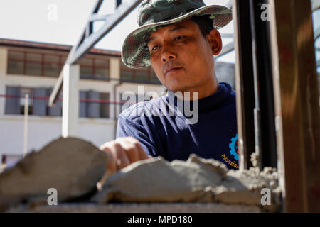 Ein Royal Thai Army Soldat mit Mobile Development unit 52, gilt konkret an einer Wand bei Ban Nong Mi Schule, Provinz Buri Ram, Thailand, während der übung Cobra Gold, Feb 1, 2017. Cobra Gold, in seiner 36. Iteration, konzentriert sich auf die humanitären Civic action, Engagement für die Gemeinschaft, und ärztlichen Tätigkeiten die Bedürfnisse und das humanitäre Interesse der Zivilbevölkerung in der Region zu unterstützen. (U.S. Marine Corps Combat Kamera Foto von Lance Cpl. Maximiliano Rosas) Stockfoto