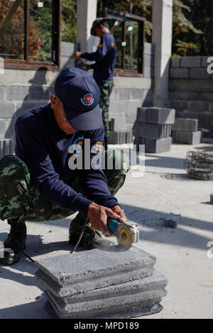 Ein Royal Thai Army Soldat mit Mobile Development unit 52, Schnitte cinder Block bei Ban Nong Mi Schule, Provinz Buri Ram, Thailand, während der übung Cobra Gold, Feb 1, 2017. Cobra Gold, in seiner 36. Iteration, konzentriert sich auf die humanitären Civic action, Engagement für die Gemeinschaft, und ärztlichen Tätigkeiten die Bedürfnisse und das humanitäre Interesse der Zivilbevölkerung in der Region zu unterstützen. (U.S. Marine Corps Combat Kamera Foto von Lance Cpl. Maximiliano Rosas) Stockfoto