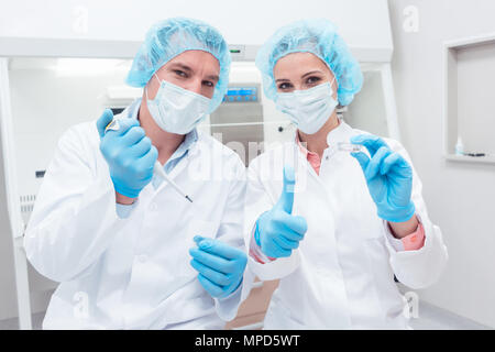 Zwei Wissenschaftler mit Werkzeugen im Labor posing Stockfoto