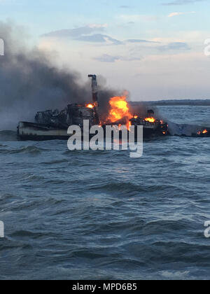 Die Küstenwache rettete drei Fischer Dienstag, nachdem ihr Schiff Brand 1 Meile östlich von St. Catherines Insel gefangen. Coast Guard Befehl Sektor Charleston Zentrum watchstanders erhielt einen Anruf vom Fischereifahrzeug auf 3:16:00 Uhr Angabe des Schiffes war in Brand und Untergang. Ein Coast Guard Station Tybee Insel 29-Fuß-Antwort Boot - Kleine boatcrew und eine Air Station Savannah MH-65 Dolphin helicopter Aircrew bei ca. 3:25 Uhr Der Delphin Crew auf der Bühne kamen um 4:30 Uhr, die Fischer gehoben und transportiert Air Station Savannah, wo EMS warteten. Es waren Stockfoto