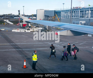 Blick aus dem Flugzeug Fenster der Himmel Brücken und Flugzeug Flügel, Flughafen Edinburgh, Schottland, Großbritannien mit Passagieren gehen über Schürze, Flugzeug Stockfoto