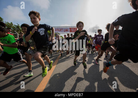 Kinder nehmen in der Jugend Kurs als Teil des weltweit bekannten Camp Hansen Schlamm laufen, auf Camp Hansen, Okinawa, Japan, 9. April 2017 statt. Die Jugend war in der Lage, entweder 1 km oder 500 Meter Relais zur Teilnahme als Erwachsene entweder 5k- oder 10k Rennen laufen würden. Die Veranstaltung bestand aus über 3.000 Läufer über 1.000 einheimische zu gehören. Stockfoto