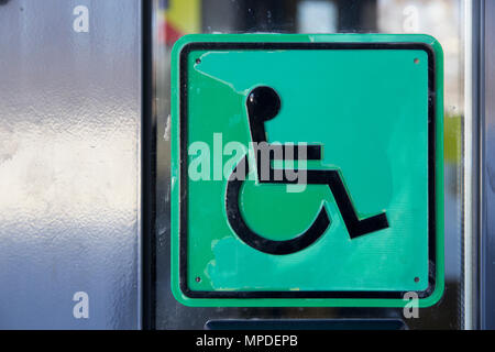 Schematische quadratischen Bild auf Glas mit Bild des behinderten Menschen im Rollstuhl Close-up Stockfoto