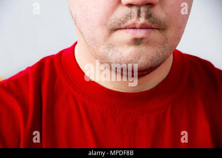 Teil des Gesichts unrasierten Mann im roten T-Shirt mit offenem Mund Stockfoto