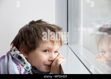 Fünf Jahre Junge auf Fensterbank und Träume lehnte Stockfoto