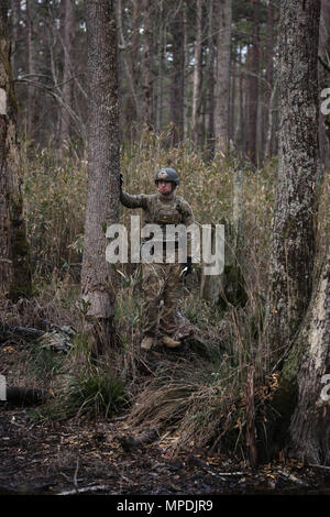 Us-Armee SPC. Andrew Brotherton, 767 . Ordnance Company, 192Nd Kampfmittel Entsorgung Bataillon (EOD), 52 Ordnance Gruppe (EOD), unterstützt sein team leader aus der Entfernung bei demontiertem Patrol als Teil der Renegade Fury Wettbewerb in Fort Bragg, N.C., 2. März 2017. Soldaten sind eine Reihe von Szenarien und entsorgt simulierten Ordnance entlang ihrer Patrouille. (U.S. Armee Foto von Pfc. Austin T. Boucher) Stockfoto