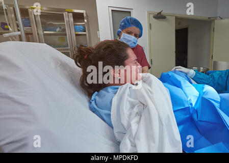 Junge Frau geben, Geburt im Krankenhaus Hintergrund. Baby Lieferung Thema Stockfoto