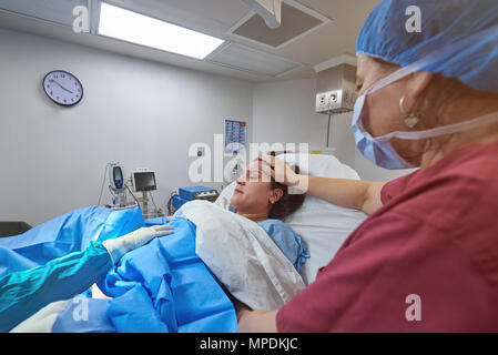 Krankenschwester helfen in Baby Lieferung in sauberes Krankenzimmer Stockfoto