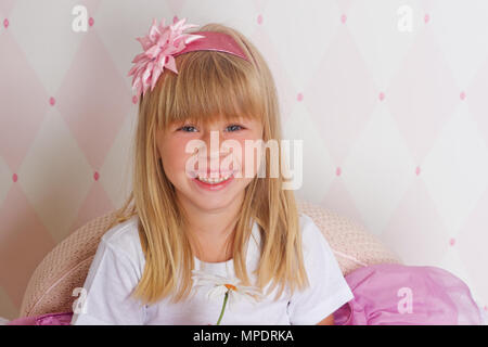 Kleines Mädchen Prinzessin sitzt auf Stuhl Stockfoto