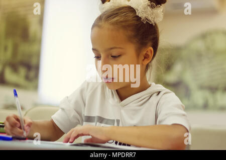 Erster Sortierer Mädchen schreibt ein Stift im Notebook Stockfoto