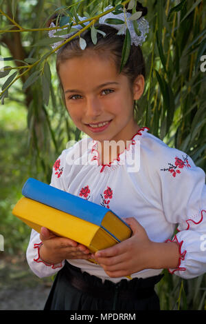 Schönes kleines Mädchen 7 Jahre in Stickerei Bücher in Farbe ukrainische Flagge Stockfoto