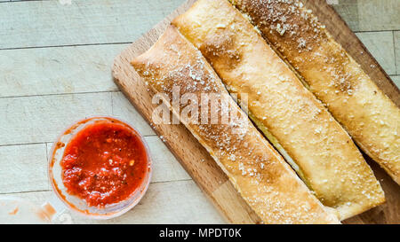 Knoblauchbrot Sticks mit Parmesan und Salsa dip Sauce. Fast Food Stockfoto