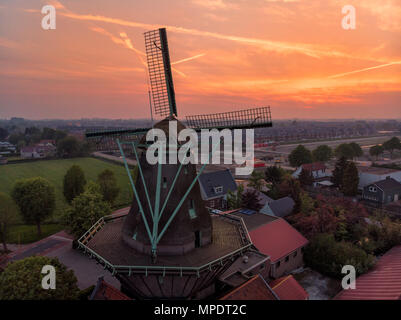 Sonnenuntergang mit einer alten Windmühle in den Niederlanden Stockfoto