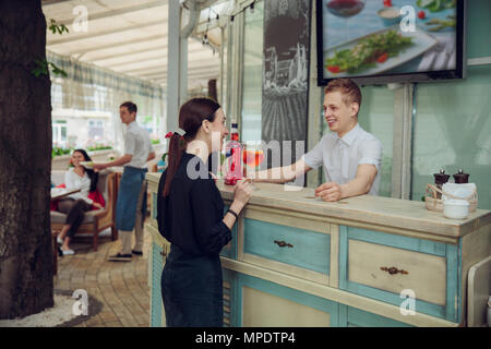 Der Mann an der Bar und Cocktail für Frau in der Nähe. Stockfoto