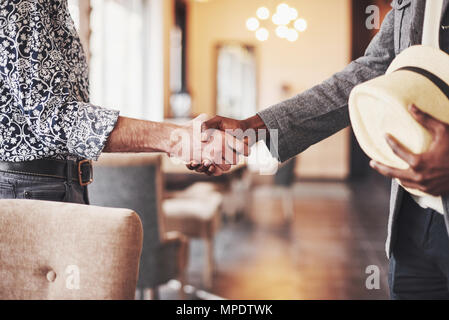 Schwarze und weiße Unternehmer zufrieden die Hände schütteln, multi-ethnischen casual Unternehmer verbindlich Geschäft mit Handshake, danken für Unterstützung in erfolgreiche Teamarbeit Stockfoto