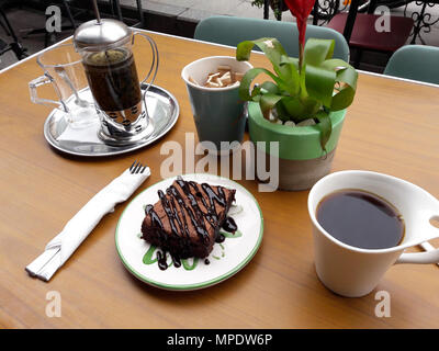 Brownie mit französischen Drücken Sie Tee und Kaffee im Garten des Café Shop. Dessert Konzept. Stockfoto