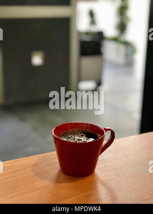 Frisch gebrühter Dämpfen Filter Kaffee in Rot Schale im Cafe Shop. Beverage Konzept. Stockfoto