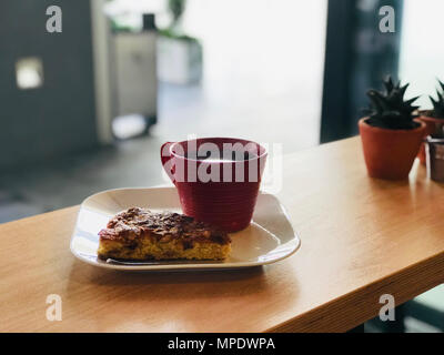 Knusprige Tortenheber mit Mandel- und Pflaumen und frischen Filterkaffee im Cafe Bar. Street Food. Stockfoto