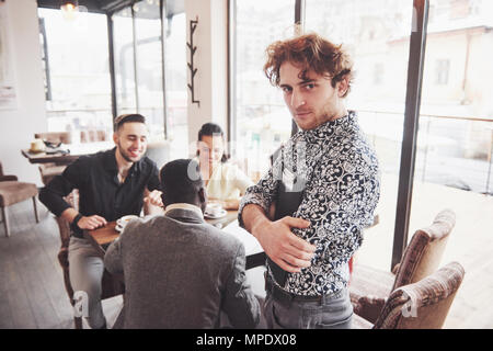 Start Vielfalt Teamarbeit Brainstorming Konzept. Business Team Mitarbeiter teilen Weltwirtschaft Bericht Dokument Laptop. Menschen, die Planung beginnen. Gruppe Junge Hipsters diskutieren Cafe Stockfoto