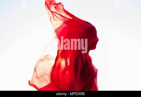 Frau eingewickelt in ein roter Schal im Wind Stockfoto