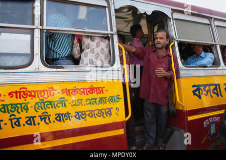 India, West Bengal, Kalkutta, ein Busfahrer steht im Fußraum eines öffentlichen Bus. Stockfoto