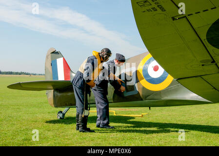 Die Schlacht um England ära Spitfire Mk 1 mit Pilot & Ground Crew Ingenieur Re-enactors erörtern scheinbare Kampf beschädigt werden. Supermarine Spitfire Mark 1 Ebene Stockfoto