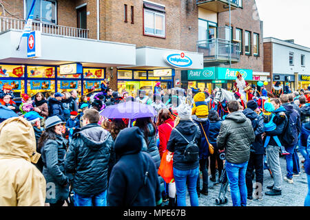 Scharen von Jungen und Mädchen für die jährliche Ankunft des Heiligen Nikolaus auf seinem weißen Pferd in der Innenstadt von Valkenburg in den Niederlanden warten. Stockfoto