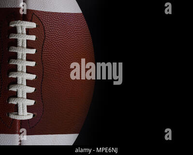 Ein American Football Spiel Ball ist in einer Geraden - Blick auf die Schnürsenkel mit schwarzen Copyspace/text Raum auf der rechten Seite dargestellt. Stockfoto