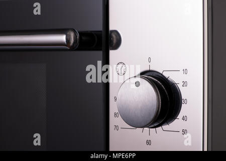 Thermostat und Griffe auf einer modernen Mikrowelle, close-up. Ausstattung der Küche Stockfoto