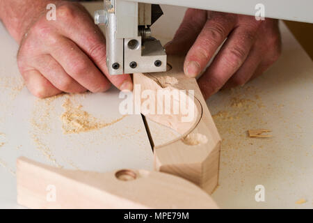 Tischler Werkzeuge auf Holztisch mit Sägemehl. Bandsäge eine komplizierte Form in ein Stück Holz zu schneiden. Carpenter Arbeitsplatz. Stockfoto
